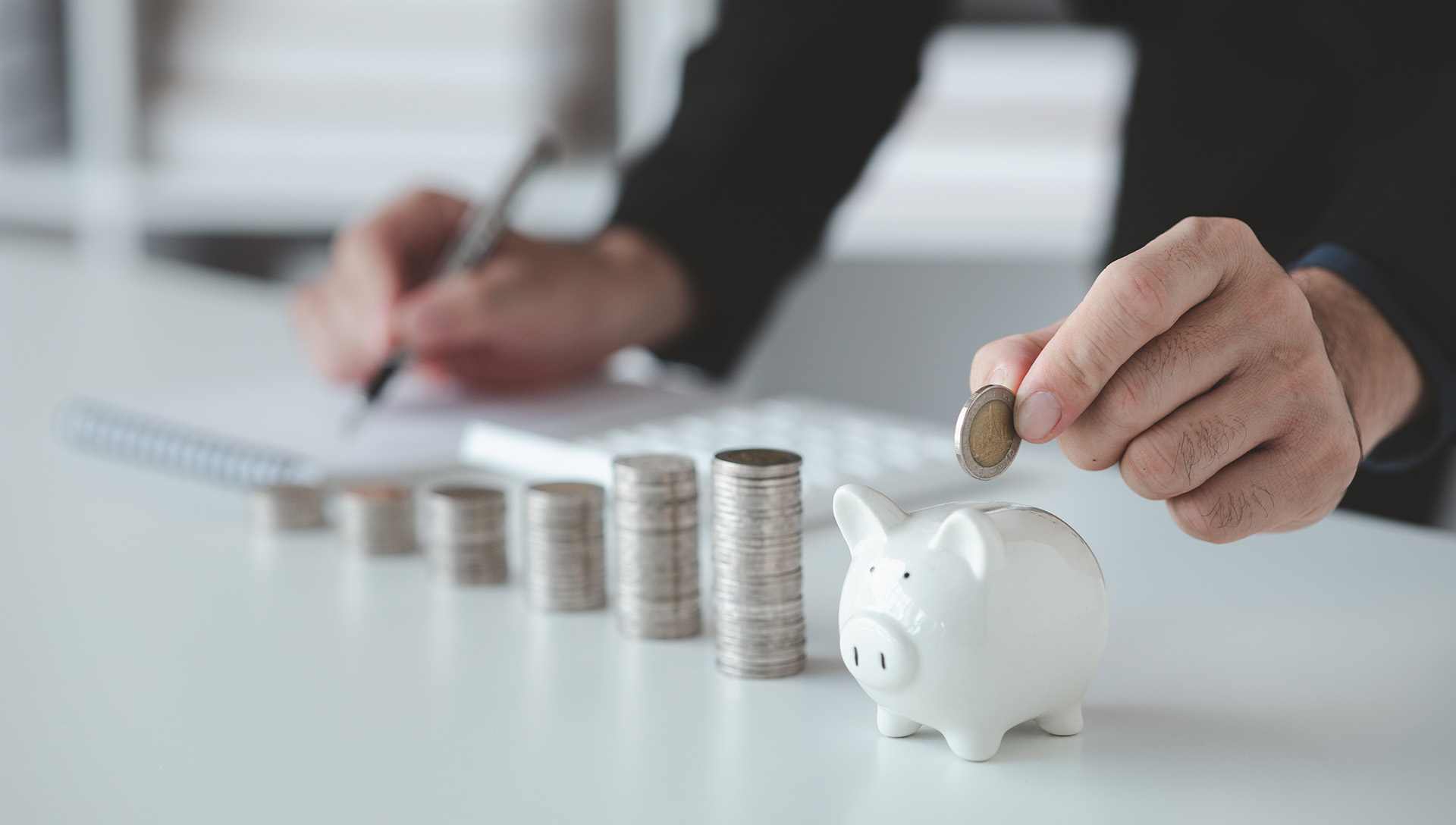 hand putting coins in a piggy bank